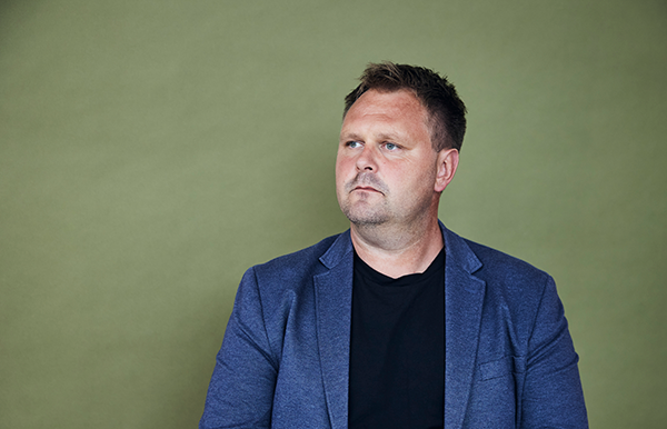Mand i blåt jakkesæt, der kigger trist til den ene side.